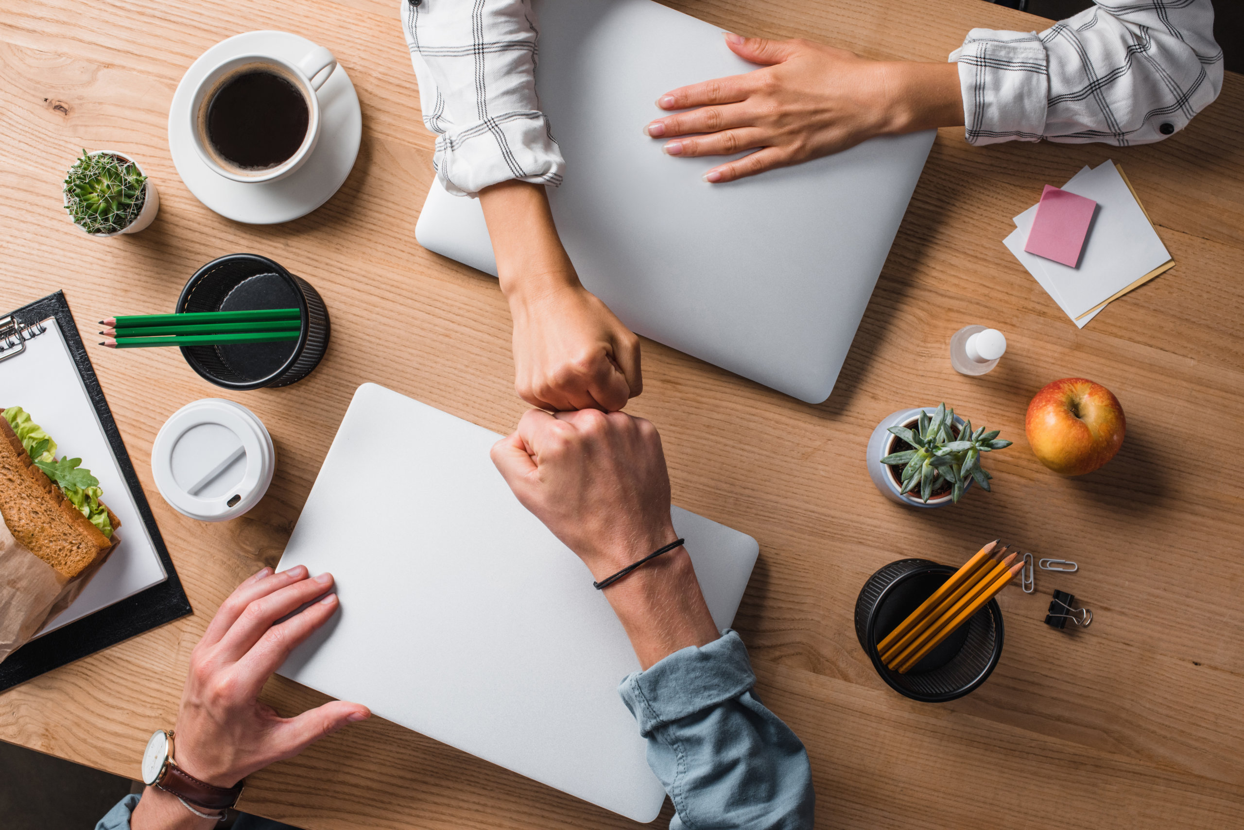 cropped shot of businesspeople doing fists gesture at workplace